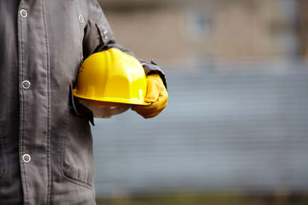 hand of builder with yellow hardhatの写真素材