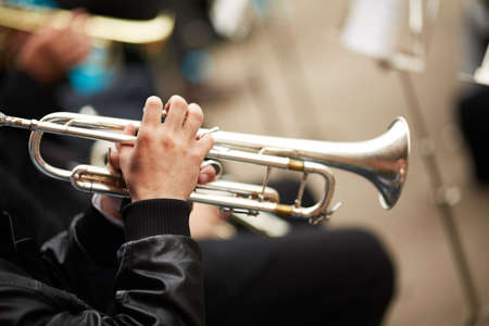 jazz band playing on the street, selective focus on the hands with trumpetの写真素材