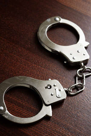 handcuffs on the wooden desk, crime concept  selective focus の写真素材