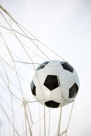 Soccer ball going into goal net の写真素材