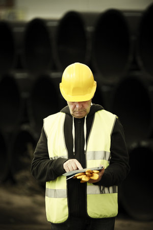 builder with small computer and gloves, selective focus on faceの写真素材