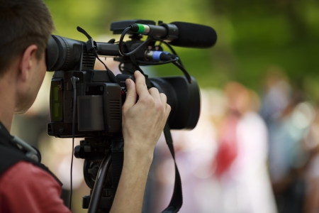 professional cameraman with camcorder on the tripodの写真素材