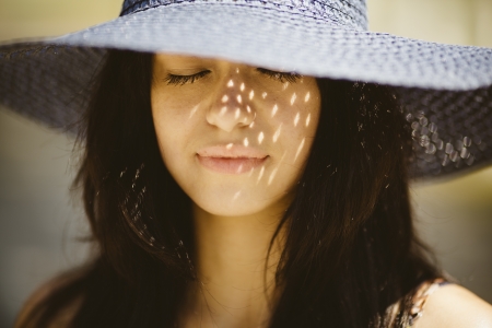Happy young woman wearing a blue hat の写真素材