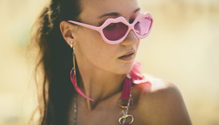 young woman with pink glassesの写真素材