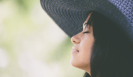 Happy dreaming girl wearing a blue hat on the sea beachの写真素材