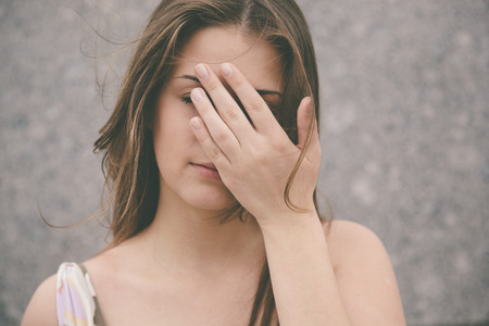 emotional stress ,woman with hand covering  the eyes, selective focusの写真素材
