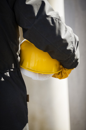 hand of worker with yellow hard-hatの写真素材