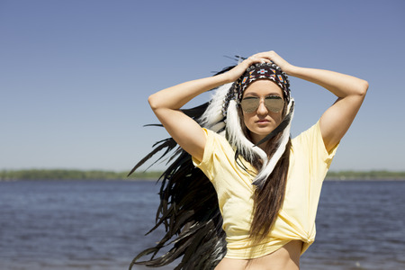 young woman in a headdress on the beach .の写真素材