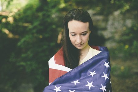 girl with the american flag deep  in the forestの写真素材