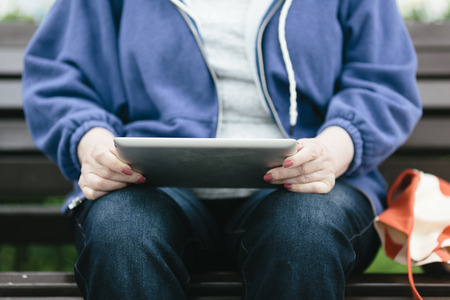 Senior woman with tablet pc on the streetの写真素材