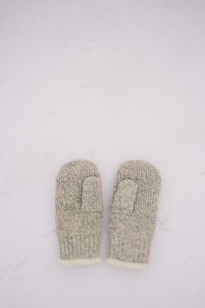 couple of wool mittens on the white snow backgroundの写真素材