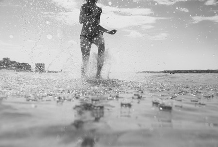 young woman running on the waterの写真素材