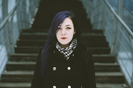 Real woman waits at an empty train stop in winter.の写真素材