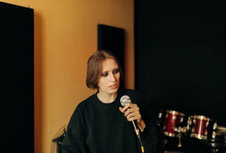 young musician with mic  in recording studioの写真素材