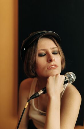 young musician with mic  in recording studioの写真素材