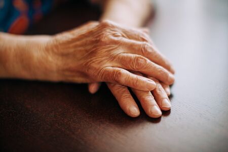 hands of real senior woman at home , natural light , selective focus pointの写真素材