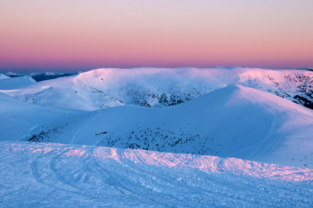 Wonderful sunrise in the Carpathians in the winter. Snow-covered summits of winter mountains in the...