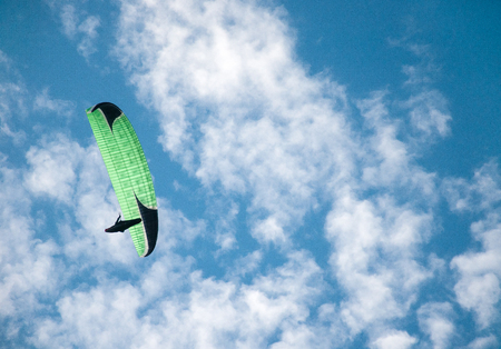 Paraglider flying in the blue sky against the background of clouds. Paragliding in the sky on a sunny day.の写真素材