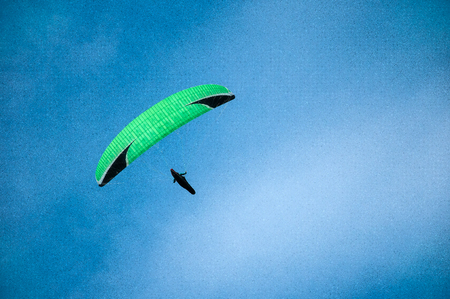 One paraglider flying against the background of clouds. Paragliding in the sky on a sunny day.の写真素材