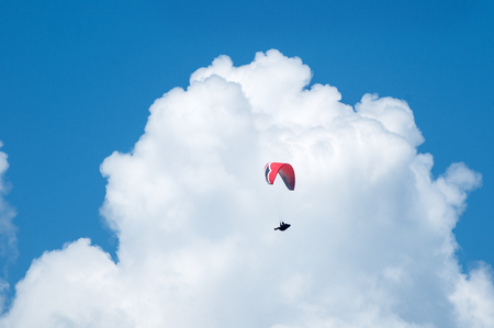 One paraglider flying against the background of clouds. Paragliding in the sky on a sunny day.の写真素材