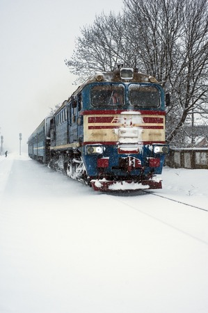 Train on the railway in heavy snow storm. Passenger train moves in winter in Ukraine.のeditorial素材