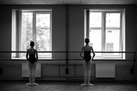 Ballerina doing stretching in the dance hall. Close-up of a ballerina in the dance hall. Black and white photography.の写真素材