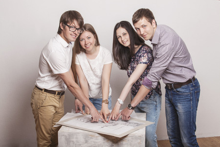 People who work with drawings on the table in the white roomの写真素材