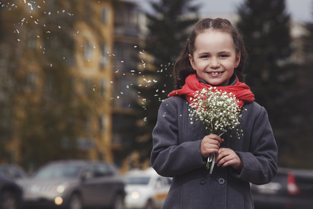 The little girl with a bouquet on a busy city streetの写真素材
