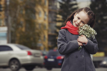 The little girl with a bouquet on a busy city streetの写真素材