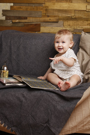 Child with a book on the couchの写真素材