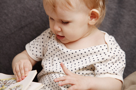Child with a book on the couchの写真素材