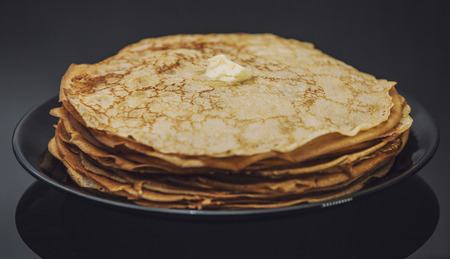 The lot of pancakes on black plate for Breakfastの写真素材
