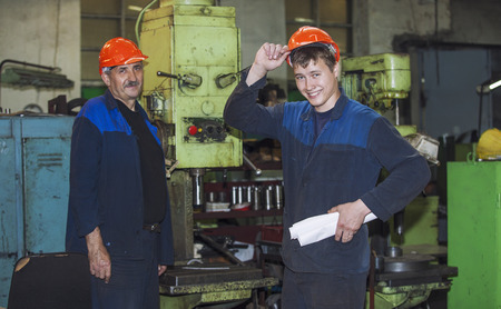 Men work on the old factory for the installation of equipment in protective helmetsの写真素材