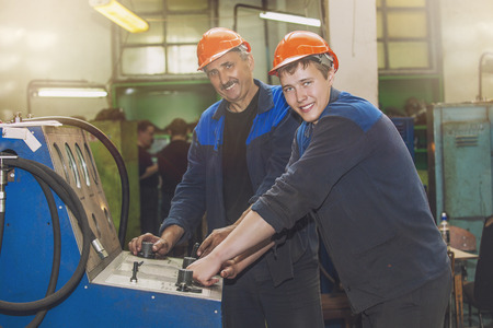 Men work on the old factory for the installation of equipment in protective helmets