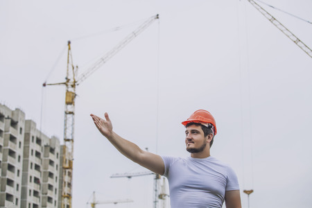Man the Builder working foreman in the helmet to ensure safety on the construction site. Worker, engineer, foreman, architect.の写真素材