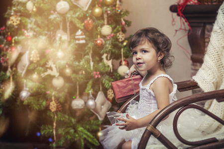 Happy little girl with gifts in beautiful boxes in the Christmas interiorの写真素材