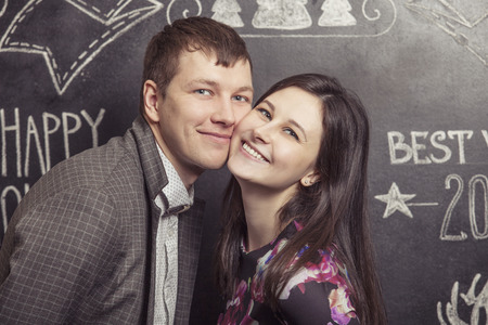 Portrait of a couple men and women on the background walls are covered with Christmas wordsの写真素材
