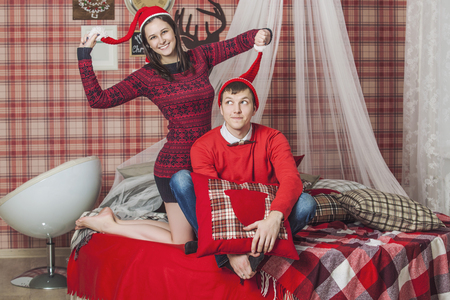 Couple man and woman in the bedroom on the bed with a blanket in the Christmas interiorの写真素材