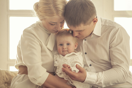 Family, mom, dad and daughter embrace together beautiful and happy close-upの写真素材