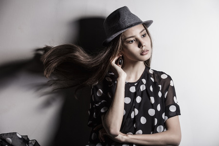 Young beautiful fashion model girl Asian girl with hat in the Studioの写真素材