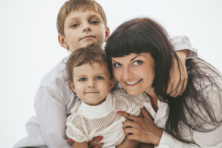 Woman smiling mother that kissing kids boy and girlの写真素材