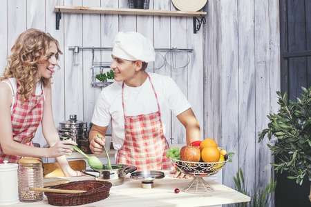 Man and woman young and beautiful couple in the kitchen home cook and have Breakfast together, helping each otherの写真素材