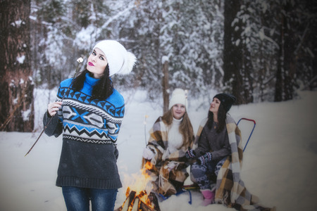 Girlfriend beautiful young women dressed warmly in winter Park in the fresh frosty airの写真素材