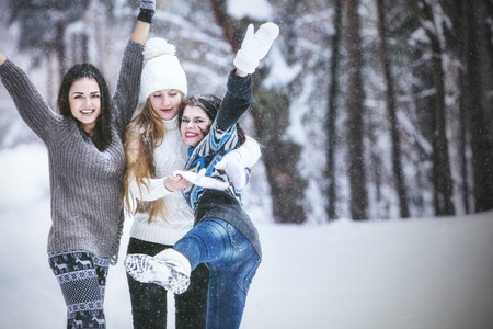Girlfriend beautiful young women dressed warmly in winter Park in the fresh frosty airの写真素材