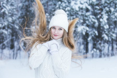 Beautiful young woman dressed warmly in winter Park in the fresh frosty airの写真素材
