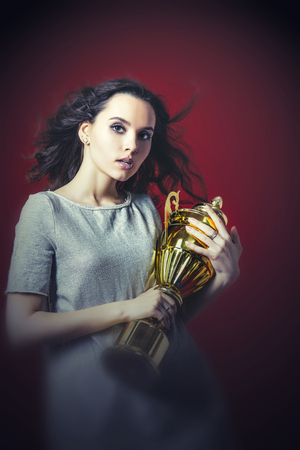 Beautiful young female model gym sexy pose with the championship trophyの写真素材