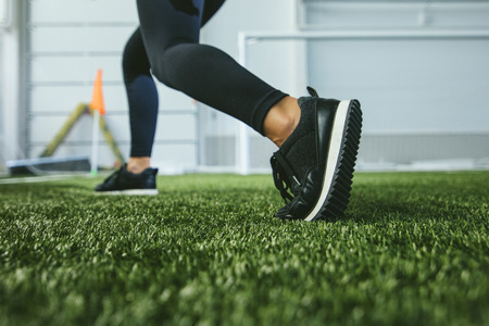 Slender young woman in sportswear is engaged in the sports stadium closeup of feetの写真素材