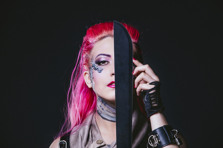 Female model with body painting futuristic on the face and clothes of punk style in the Studioの写真素材