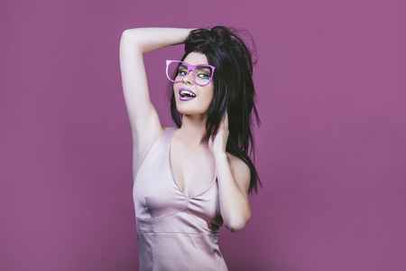 Model woman young and beautiful in the style of pop art on a pink background in pink painted glassesの写真素材