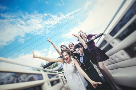 Young beautiful happy women celebrate bachelorette party in a convertible limousineの写真素材